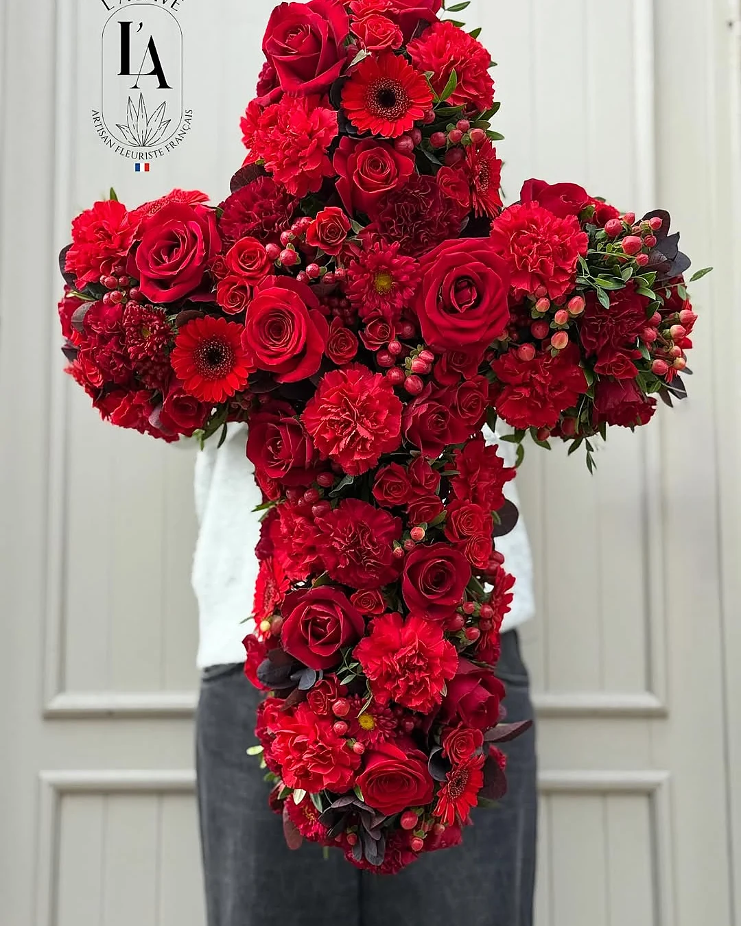 Croix de roses rouges et d’œillets