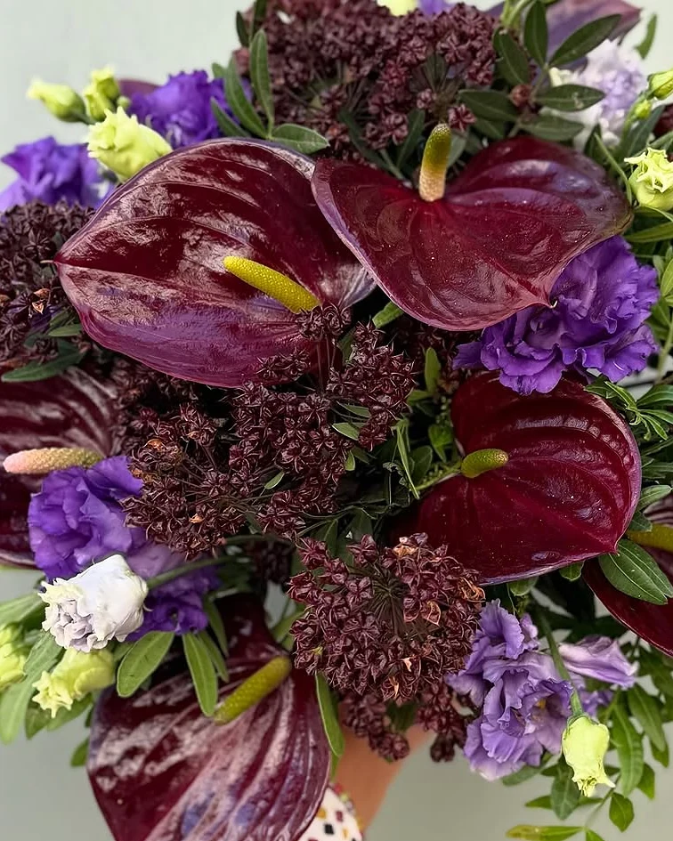 Bouquet d’anthuriums bordeaux, de lisianthus violets et de skimmia, composé à la boutique