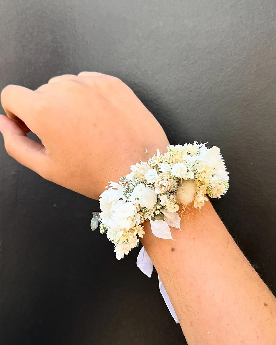 Bracelet de fleurs blanches au poignet